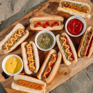 hotdog sandwich with sauce on brown wooden tray